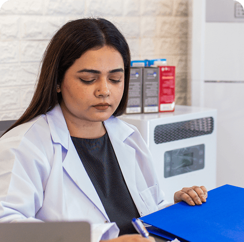 Doctor in lab coat reviewing documents at desk
